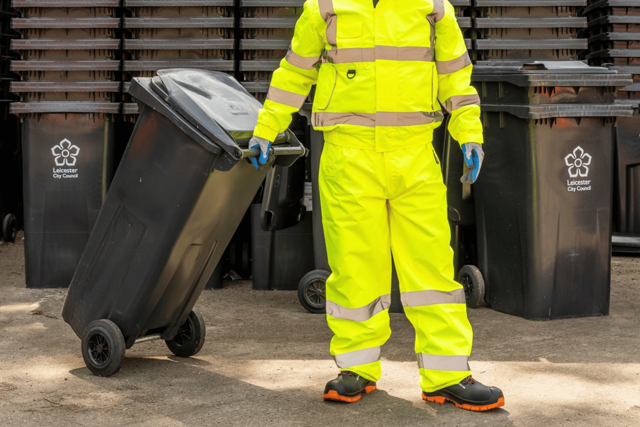 Man pulling a black bin.