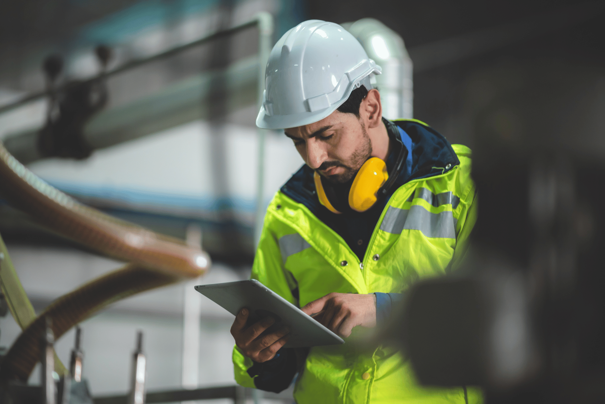 Man wearing PPE and hi-vis conducting an inspection.