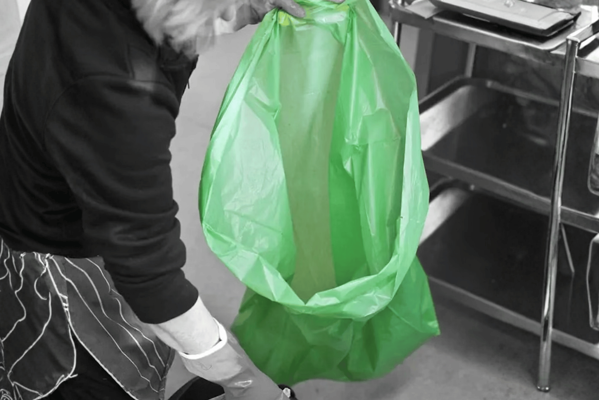 Binning items into a waste bag.