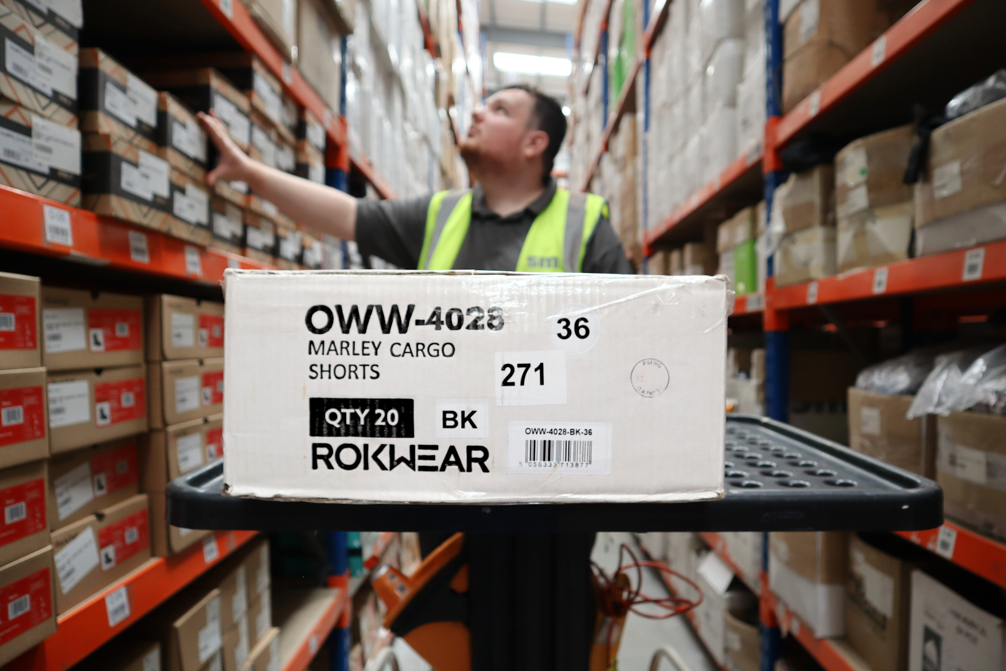Man in hi-vis inside a warehouse.