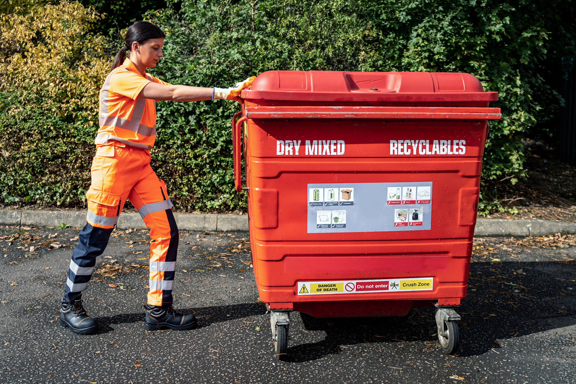 Woman pushing waste bin in Hi-Vis Ballistic Trousers