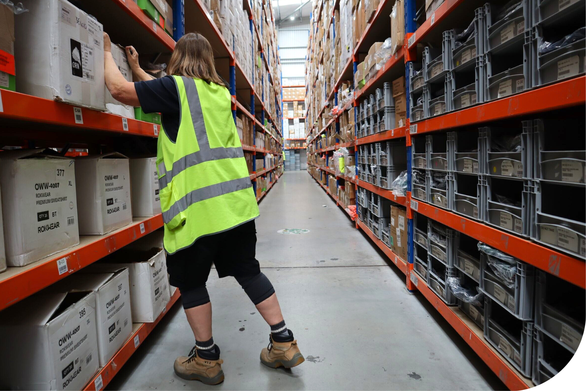 Woman in hi-vis in a warehouse.