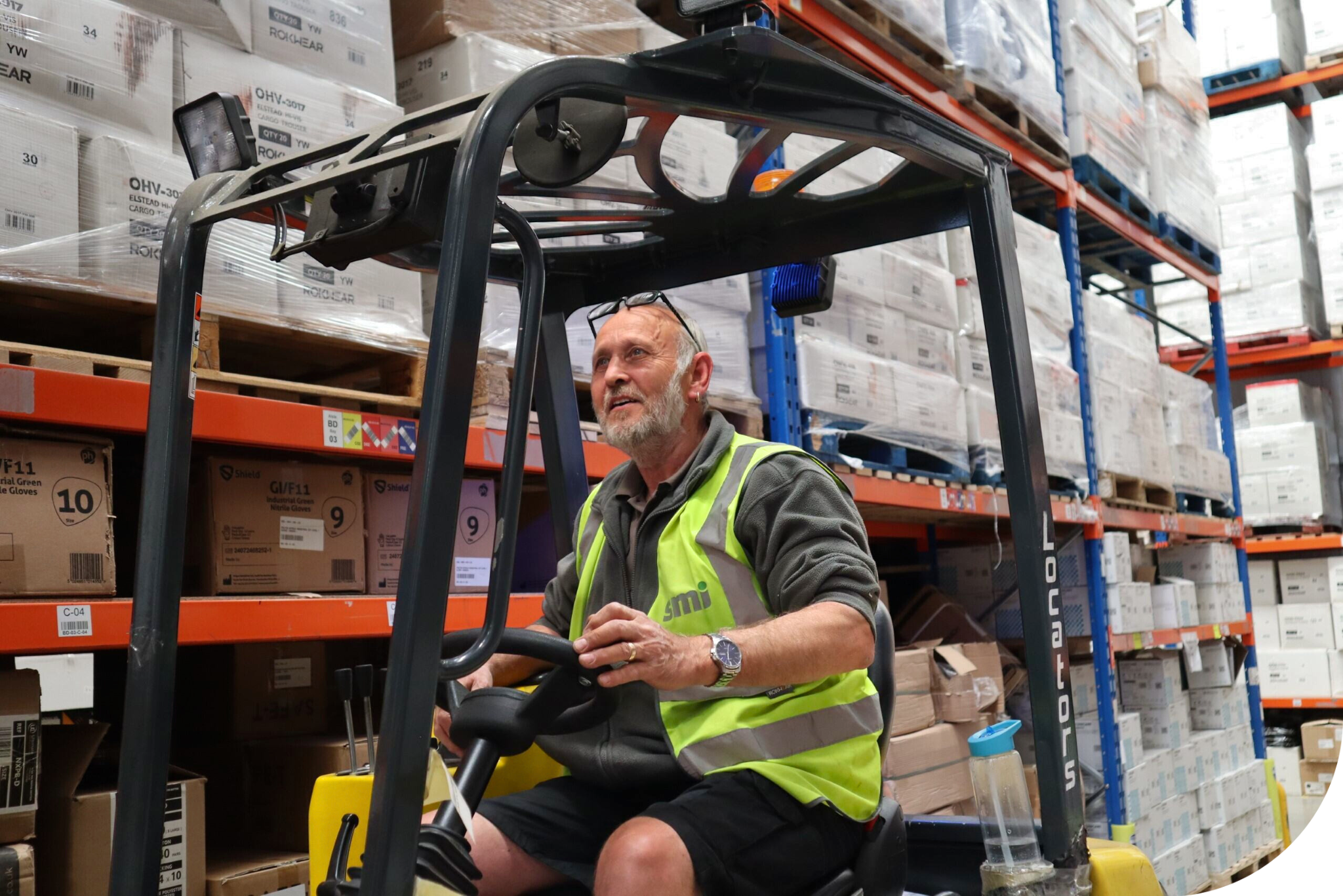 Man in hi-vis driving a forklift.