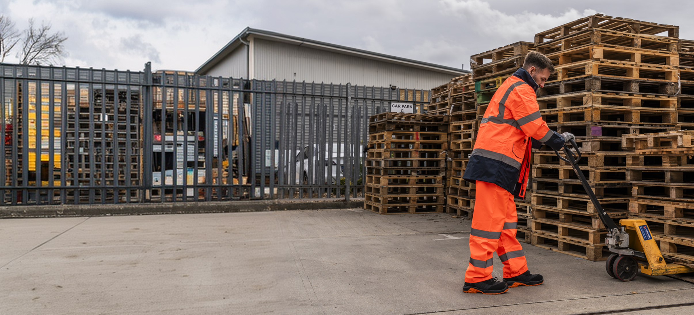 Warehouse worker operating a manual pallet truck.
