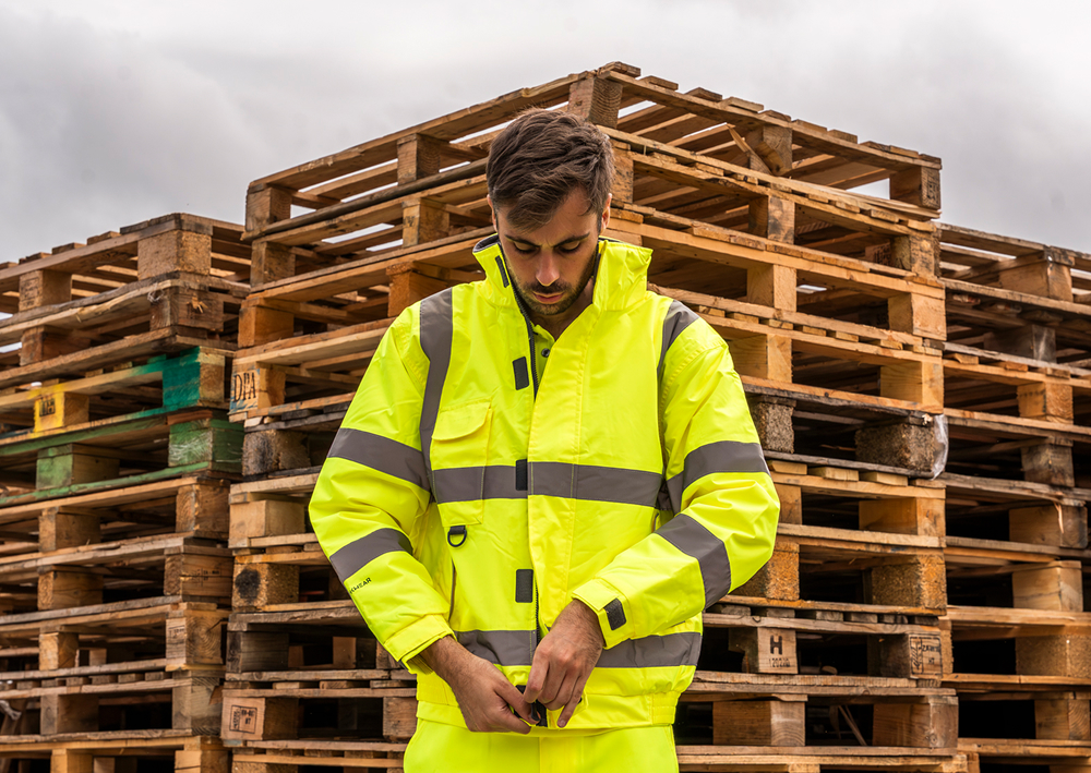 A man putting on a hi-vis jacket.