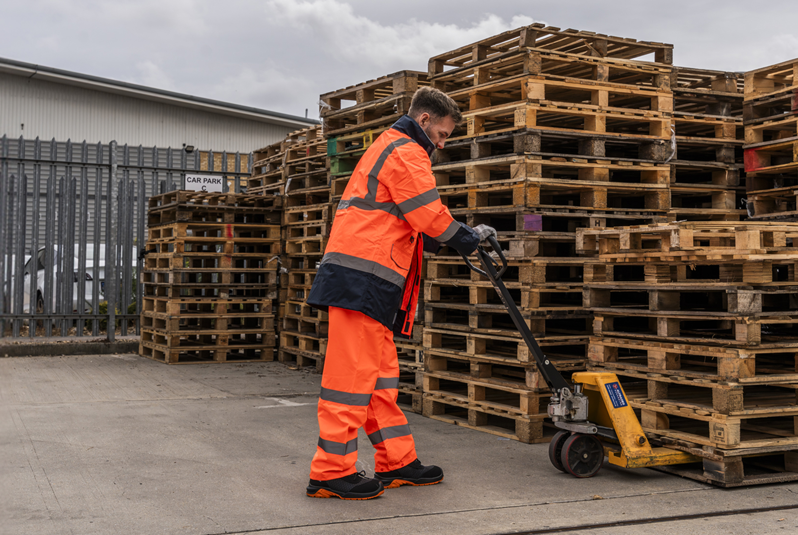 Warehouse worker operating a manual pallet truck.