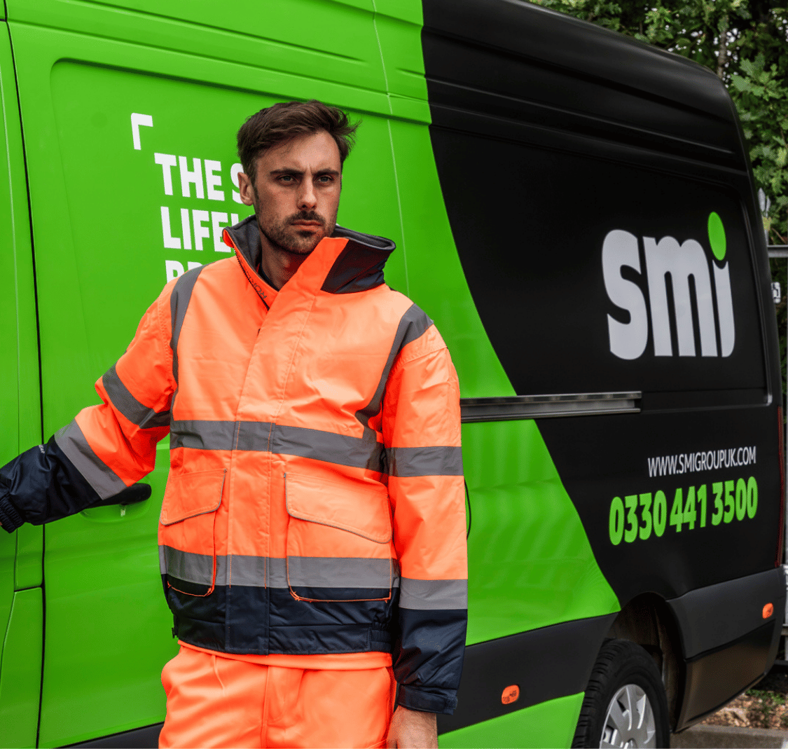 Man in hi-vis orange workwear in front of a delivery van.